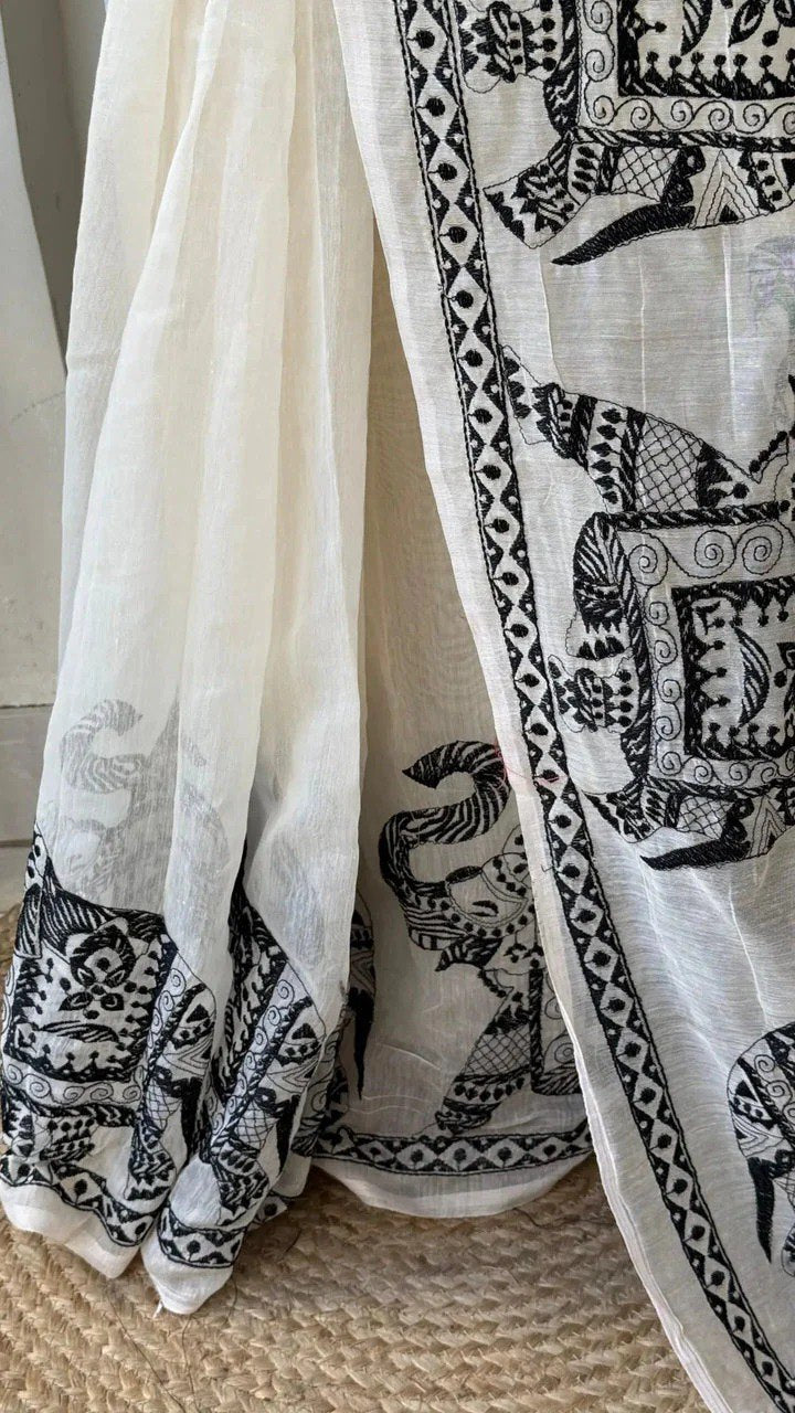 Woman wearing a white linen cotton saree with black elephant print