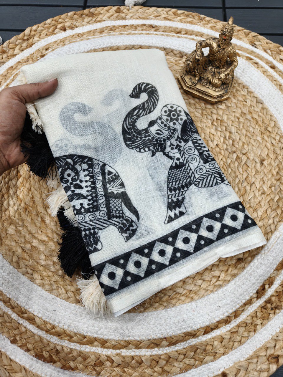 Woman wearing a white linen cotton saree with black elephant print