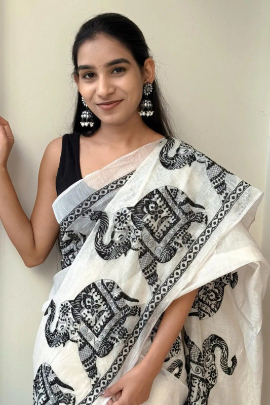 Woman wearing a white linen cotton saree with black elephant print