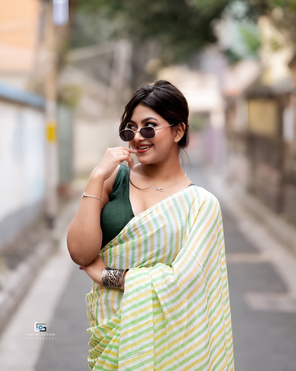 Woman wearing pastel green and yellow striped linen cotton saree