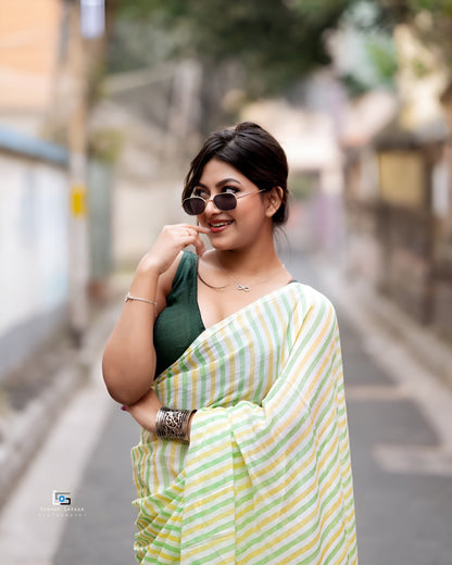 Woman wearing pastel green and yellow striped linen cotton saree