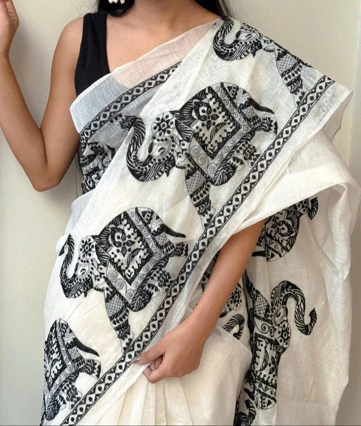 Woman wearing a white linen cotton saree with black elephant print