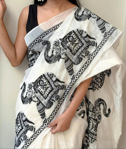 Woman wearing a white linen cotton saree with black elephant print