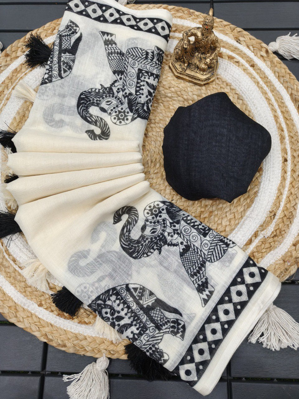 Woman wearing a white linen cotton saree with black elephant print