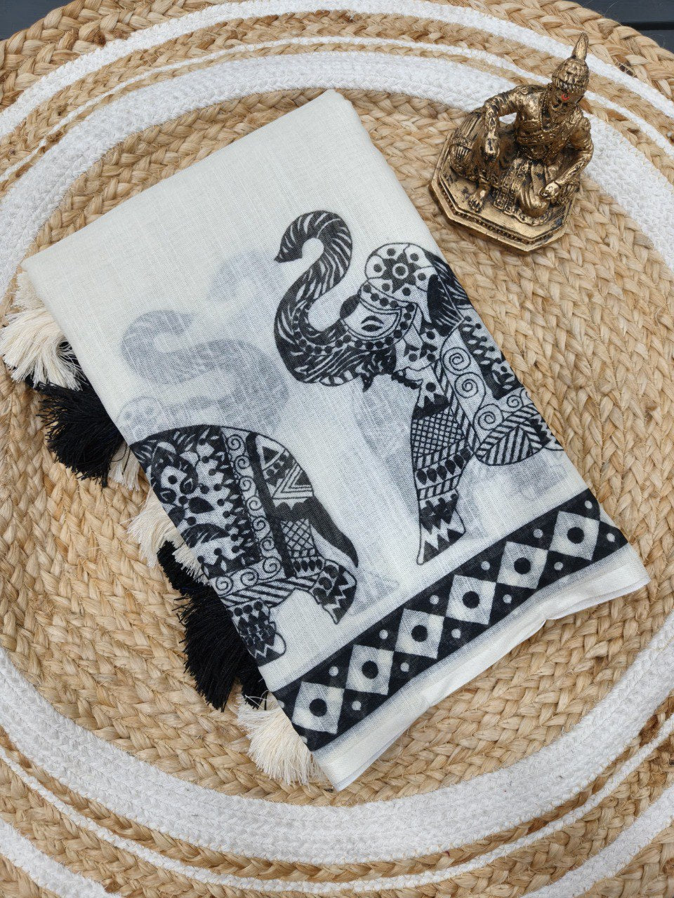 Woman wearing a white linen cotton saree with black elephant print