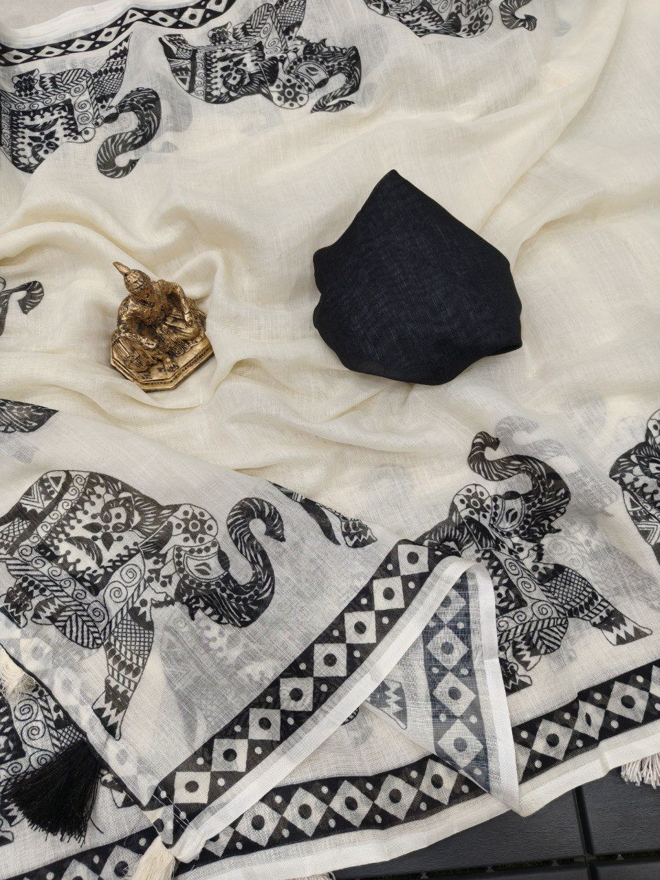 Woman wearing a white linen cotton saree with black elephant print
